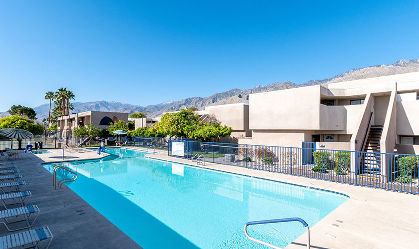 Pool with pool chairs and building at Vista Mirage Resort with mountains in background