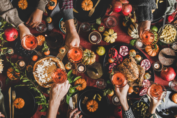 thanksgiving dinner table with pumpkins and food and drinks