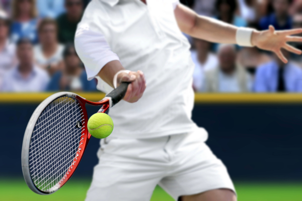 tennis player holding racket hitting tennis ball