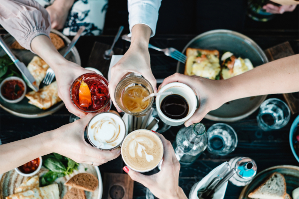 group of friends holding drinks together at a restaurant