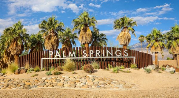 palm springs welcome sign with palm trees in the background